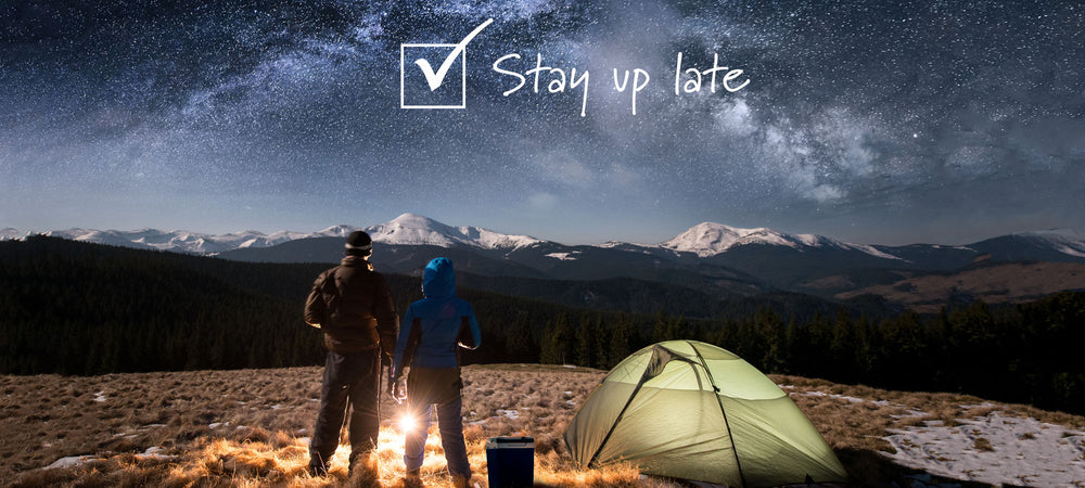 Two people looking a wonderfully dense starry sky in winter with a tent and campfire and Circle Back