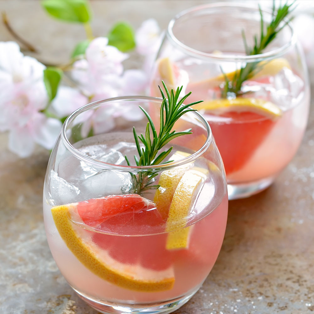 Round glass with rosemary, fruit and Circle Back Fizz